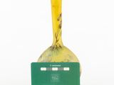 a yellow vase with a green label on it