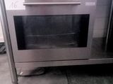 a stainless steel oven that is sitting on a tiled floor