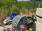 a trash can sitting on the side of the road next to a fence