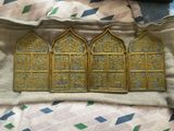 three gold colored metal windows on a white blanket