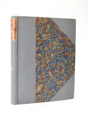 an old book sitting on top of a white table next to a white wall