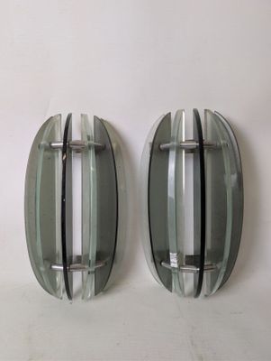 two oval mirrors on the wall next to each other