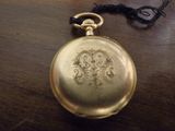 une montre de poche en or posée sur une table en bois