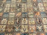 an image of a patchwork area rug with a cat sitting on the floor