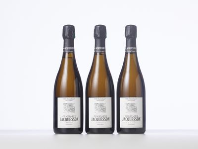 trois bouteilles de vin posées sur une table blanche