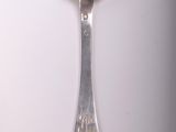a silver spoon with a spoon handle on a white surface