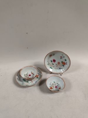 three pieces of porcelain tea cups and saucers on a white surface