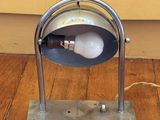 une lampe posée sur le sol à côté d'un mur