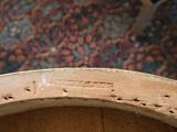 a close up view of a wooden chair with holes in it