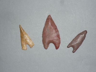 trois pointes de flèche de couleurs différentes posées sur une surface grise