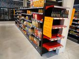 many shelves in the store that have various drinks on them