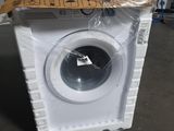 une machine à laver blanche posée au milieu d'une pièce