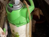 a green and white fire hydrant with a hose attached to it