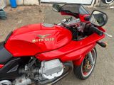 a red motorcycle parked on the side of the street
