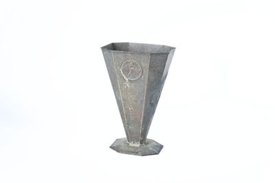 un vase argenté orné d'une étoile sur un fond blanc