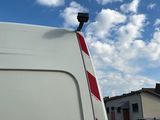 une camionnette blanche garée sur un parking, avec une caméra à l'arrière