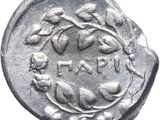 a silver coin with a branch and leaves on it