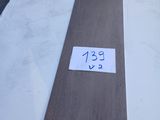 Dans un entrepôt, des planches de bois sont empilées les unes sur les autres.