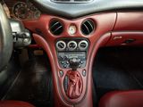 a dashboard of a car with red leather seats and dashboard controls