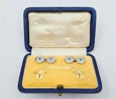 une photo d'une paire de boutons de manchette dans un étui