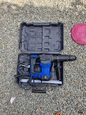 un outil dans une mallette posée par terre à côté d'un objet rouge