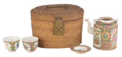un panier en osier contenant une théière, des tasses et une théière