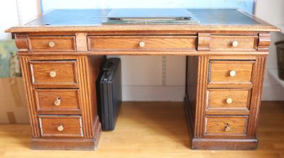 a wooden desk with drawers and a laptop on top of it