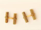 pair of gold tone cufflinks with a knot on each end