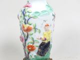 un vase posé sur un socle et contenant des fleurs
