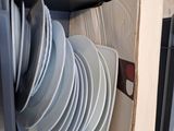 a lot of plates in the open drawer of the oven