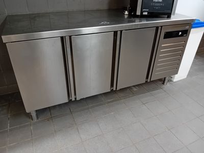 un comptoir en acier inoxydable surmonté d'un micro-ondes