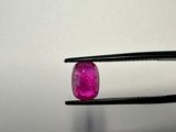 a close up of a pair of pliers holding a pink diamond