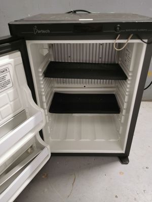 a small black and white refrigerator with its door open