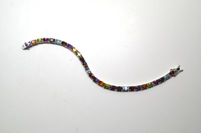 un bracelet composé de perles de verre multicolores sur un fond blanc