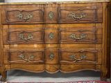 une commode en bois avec un plateau en marbre dans une chambre
