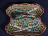 a green tray with a purse and two spoons on it