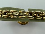 gold tone bracelet with a green velvet band and a gold tone clasp