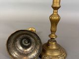 a pair of brass candlesticks on a grey background