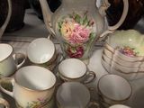 many cups and saucers sitting on a table