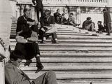photo en noir et blanc d'un homme assis sur les marches d'un immeuble