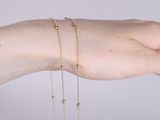 someone wearing a gold chain bracelet and a gold beaded bracelet
