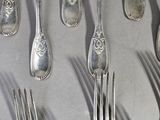 a lot of silver spoons and forks on the table
