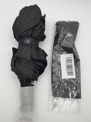a black umbrella and a black bag on a white table
