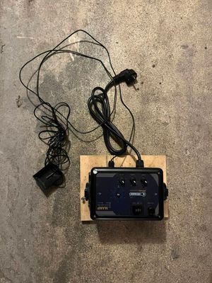 une télécommande posée par terre à côté d'un chargeur