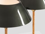 a pair of black lamps with gold bases on a white surface