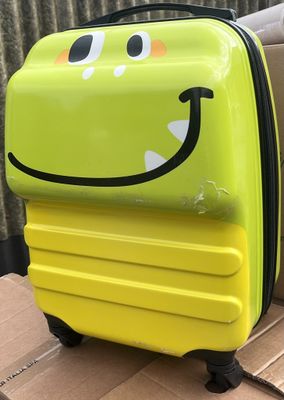 un gros plan d'une valise jaune ornée d'un smiley