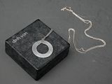une petite boîte posée sur une table, sur laquelle est posé un collier