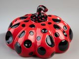 a red and black pumpkin with black dots on it