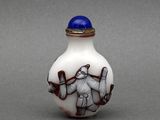 une image représentant une fiole à priser en verre blanc et bleu, sur laquelle figure un homme tenant une batte de baseball