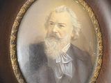 portrait of a man with a beard and a bow tie in a wooden frame